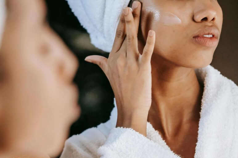 a girl applying cream on face