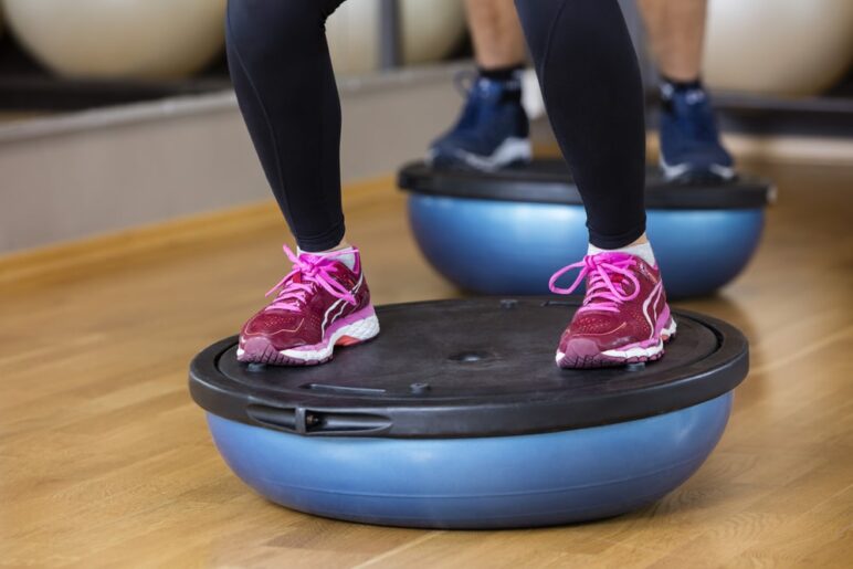 girl standing on bosu ball